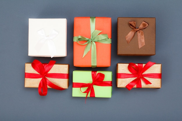 Gift boxes with red and green ribbons on gray background. Celebration day concept. Top view.