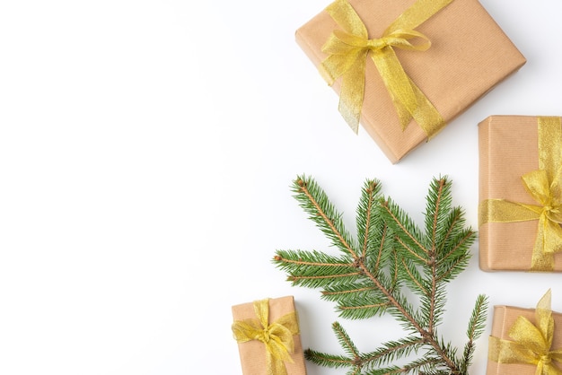 Gift boxes wrapped in brown paper and tied with a golden ribbon on a white background, top view, copy space