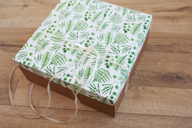 Gift in craft paper on a white textile background Wrapped parcels top view close up