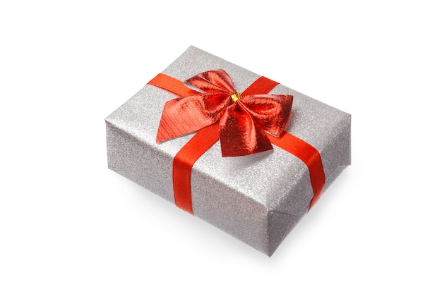 Gift in festive silver packaging are tied with a red ribbon with a bow on a white table, isolate.