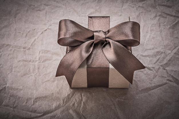 Giftbox with present ribbon on wrapping paper holidays concept