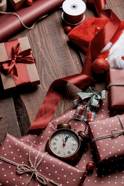 Gifts and red paper in wrapping time on wooden table