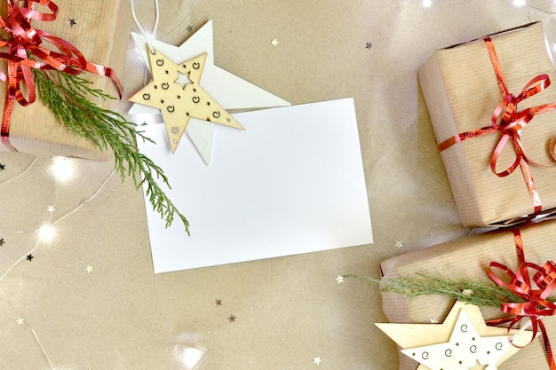 Gifts and scattered glitter stars on a beige craft paper background with lights and white sheet.