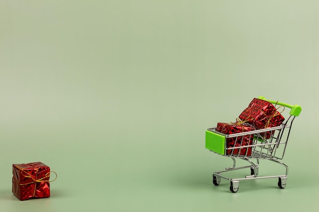 Gifts in a shopper trolley on a green background.