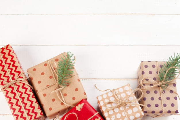 Gifts wrapped with craft paper on white wooden table