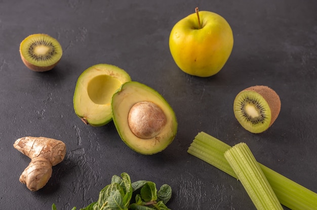 Ginger, avocado, apple, kiwi, celery on a dark background. Ingredients for smoothies