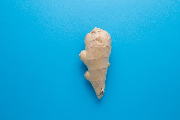 Ginger on a blue background close-up. Prevention of virus diseases.