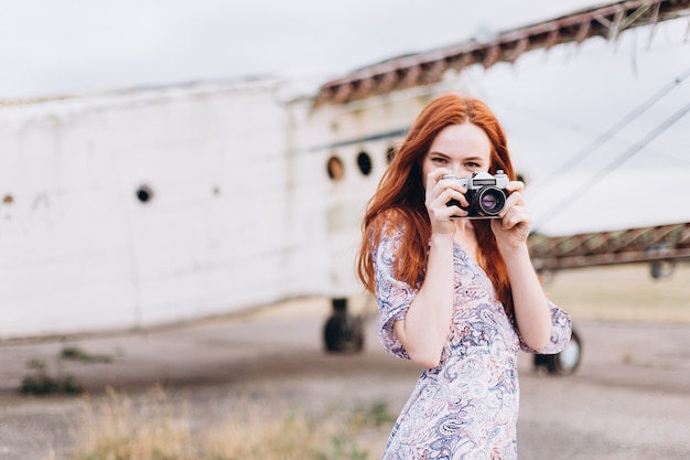 Ginger girl photographer shooting outdoors 