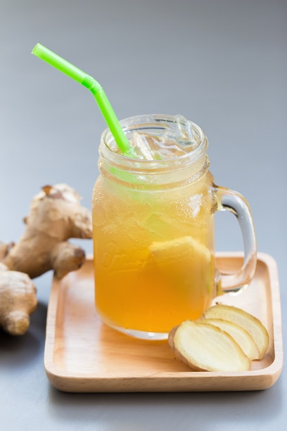 Ginger juice with sugar on gray table.