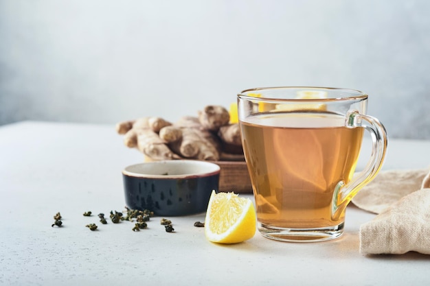 Ginger tea. Cup of ginger tea with lemon, honey and mint on grey background. Concept alternative medicine, natural homemade remedy for cold and flu. Top view. Free space for your text.