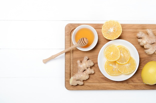 Ginger with lemonand herbal tea on wooden desk on white background