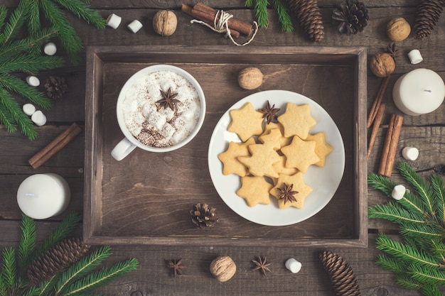 Gingerbread Cookie in the form of stars and cup of cocoa on rustic tray. Christmas food background.