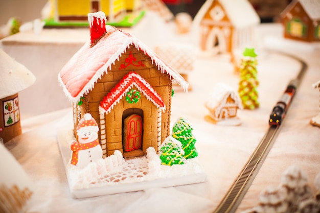 Gingerbread cookie house in the Christmas village on the fair. Holiday traditional aroma dessert with honey and spices