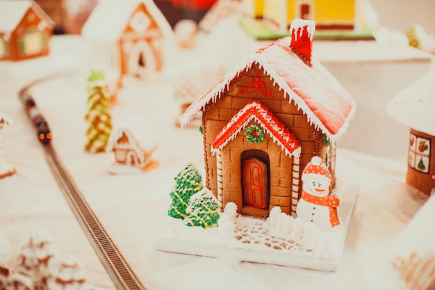 Gingerbread cookie house in the Christmas village on the fair. Holiday traditional aroma dessert with honey and spices