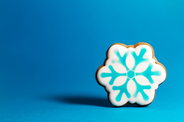 Photo gingerbread cookie of snowflake on blue