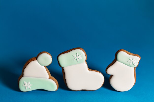 Gingerbread cookie of white Santa's clothes on blue . Traditional Christmas food. Christmas and New Year holiday . Copyspace