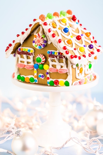 Photo gingerbread house decorated with white royal icing and bright candies.