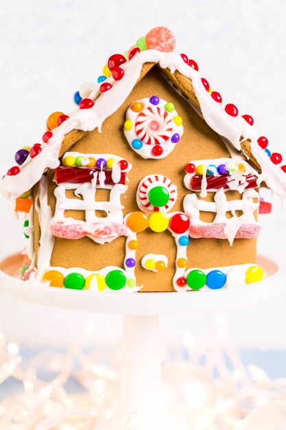 Photo gingerbread house decorated with white royal icing and bright candies.