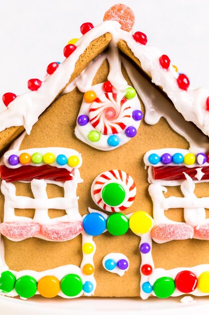 Photo gingerbread house decorated with white royal icing and bright candies.