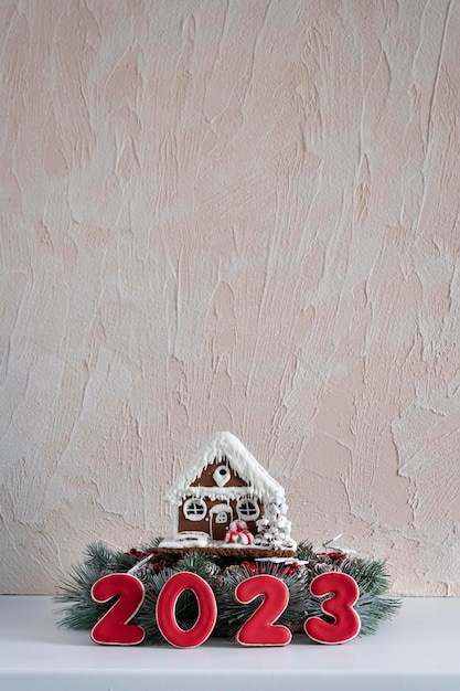 Gingerbread house and Inscription 2023 Merry Christmas background copy space Light gray wall on background