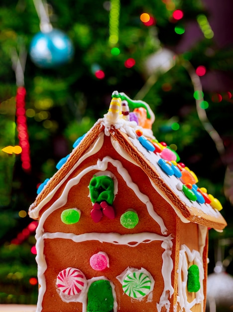 Gingerbread house with peppermint candies and christmas tree