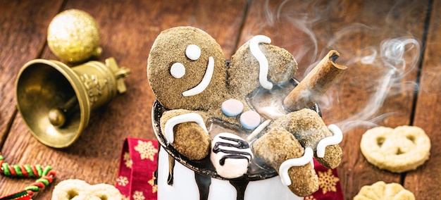 Gingerbread man cookie sitting inside christmas hot chocolate mug. Fun image on vacation or lounging on winter vacation