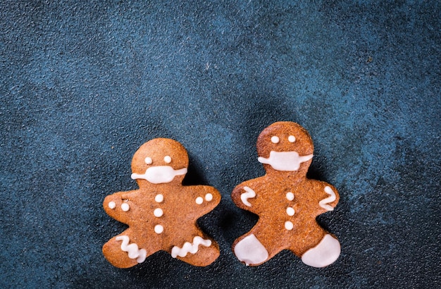 Gingerbread man in face mask. Gingerbread man in medical mask. Stay home, coronavirus concept. Pandemic christmas. Cookie couple in mask. New year covid 19.