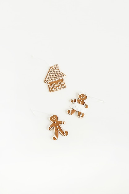 Gingerbread man, woman and house cookies isolated on white surface. Flat lay, top view