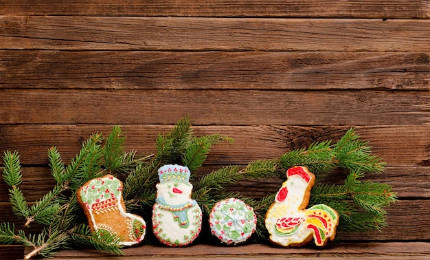 Gingerbread sock snowman ball and cock spruce branch on a background of a wooden wall with space for text