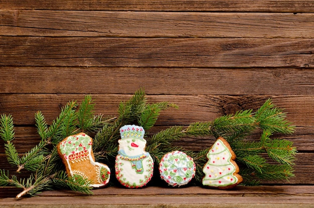 Gingerbread sock snowman ball and firtree spruce branch on a background of a wooden wall with space for text