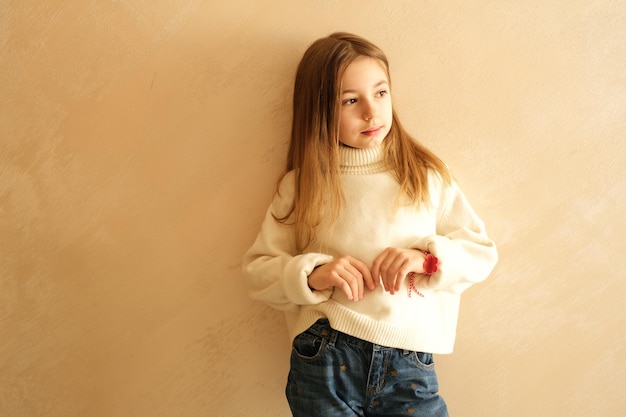 girl 9 years old with long hair model schoolgirl at home lifestyle on a beige background portrait