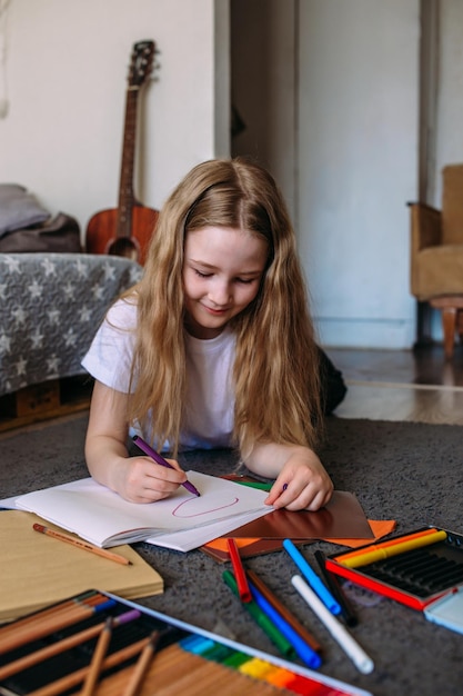 the girl after school plays at home draws with pencils and felttip pens