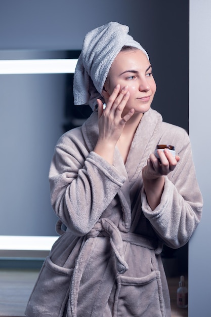 The girl applies face cream. Skin care, healthy lifestyle, cosmetology, dermatology.