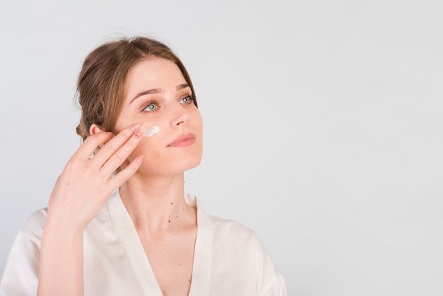 Girl applying herself cosmetic product