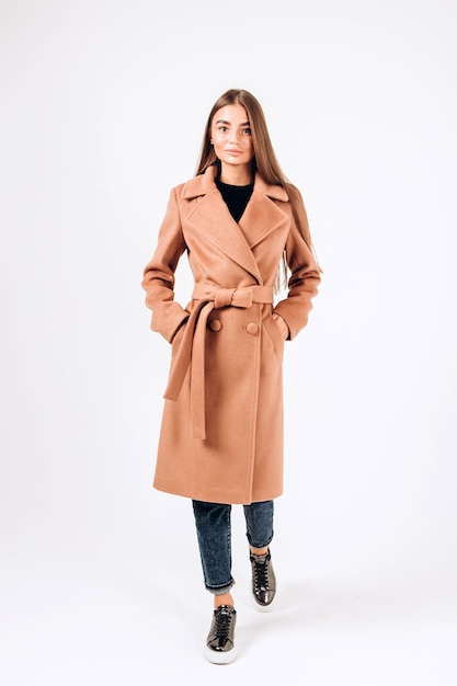 Girl in autumn coat on a white background