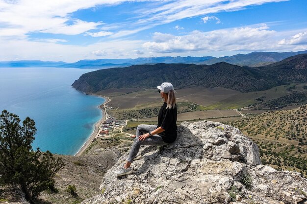 A girl on the background of the Black Sea and the Crimean mountains on the Golitsyn trail Crimea