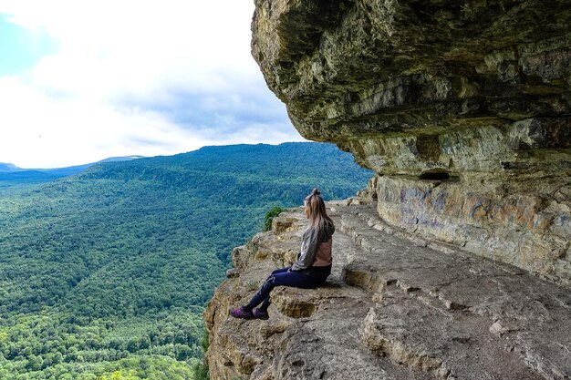 A girl on the background of the landscape of the Caucasus Mountains The Eagle Rocks Mountain shelf Mezmai