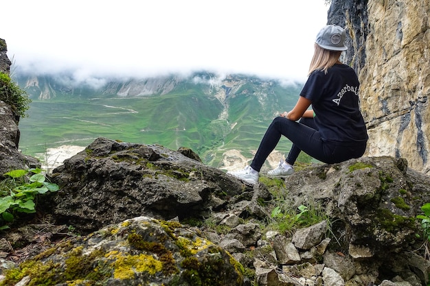 A girl on the background of a mountain landscape in the clouds Stone bowl in Dagestan Russia