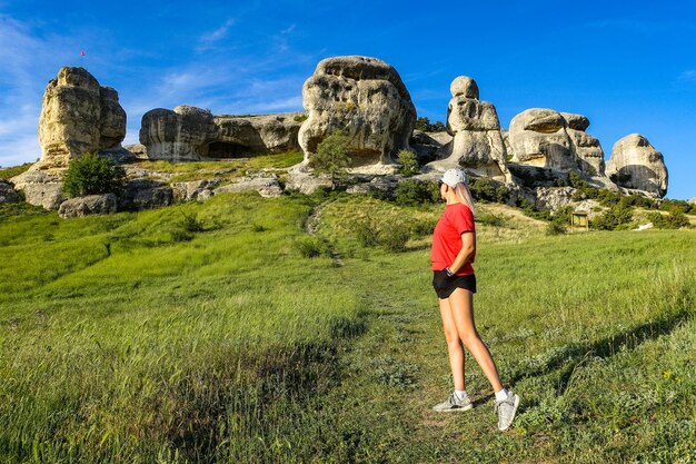 A girl on the background of a picturesque view of the Bakhchisarai sphinxes in summer Bakhchisarai May 2021