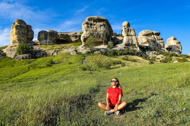 A girl on the background of a picturesque view of the Bakhchisarai sphinxes in summer Bakhchisarai May 2021