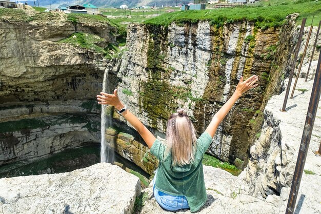 Girl on the background of Tobot waterfall Khunzakh waterfalls Dagestan Russia 2021