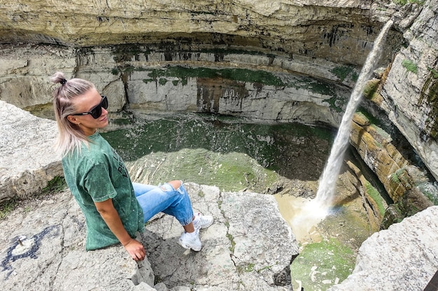 Girl on the background of Tobot waterfall Khunzakh waterfalls Dagestan Russia 2021