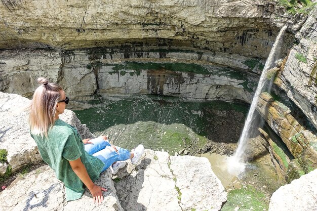 Girl on the background of Tobot waterfall Khunzakh waterfalls Dagestan Russia 2021