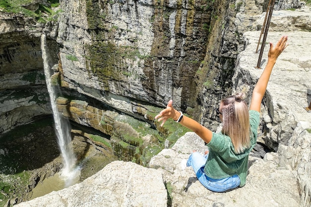 Girl on the background of Tobot waterfall Khunzakh waterfalls Dagestan Russia 2021