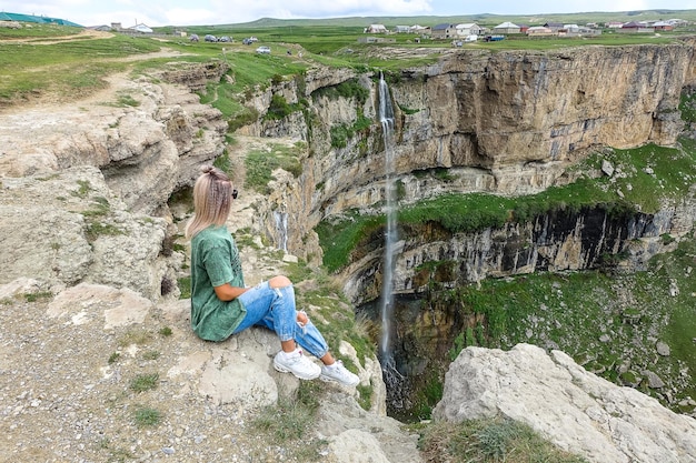 Girl on the background of Tobot waterfall Khunzakh waterfalls Dagestan Russia 2021