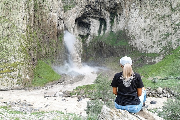 A girl on the background of the TuzlukShapa waterfall on the territory of KabardinoBalkaria Caucasus Russia