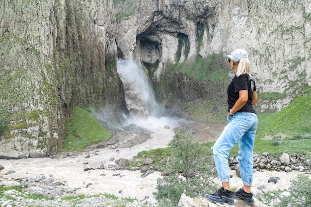 A girl on the background of the TuzlukShapa waterfall on the territory of KabardinoBalkaria Caucasus Russia