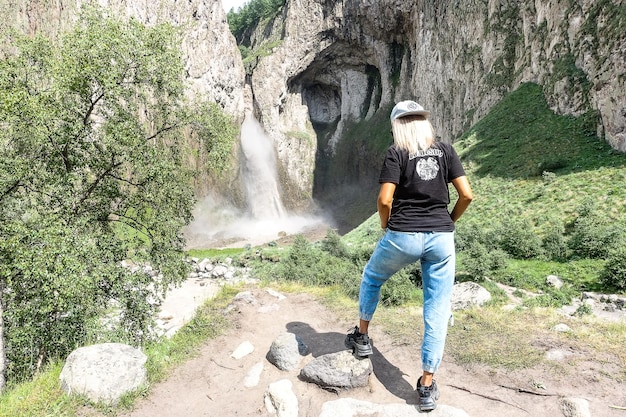 A girl on the background of the TuzlukShapa waterfall on the territory of KabardinoBalkaria Caucasus Russia