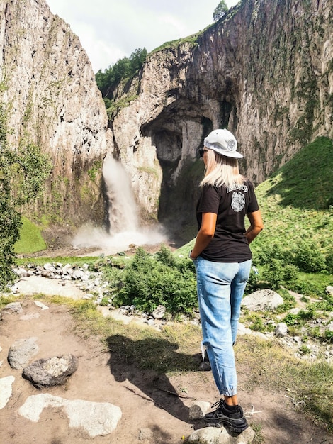 A girl on the background of the TuzlukShapa waterfall on the territory of KabardinoBalkaria Caucasus Russia