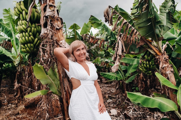 A girl on a banana plantation on the island of Mauritius, a Banana farm on a tropical island, a Girl in a white dress on a plantation in Africa.